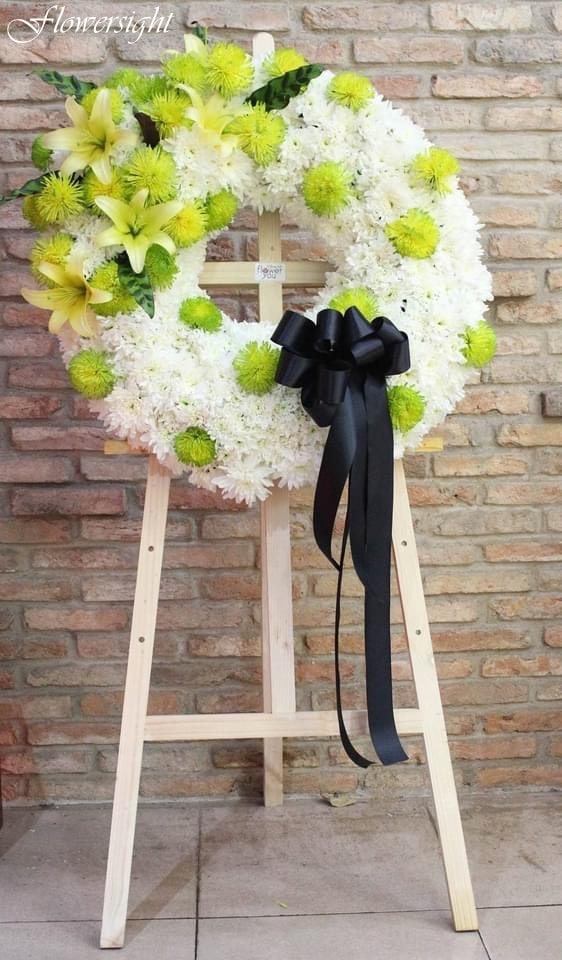 Những bông hoa trắng bao quanh các loại vải, ruy băng màu đen được tạo hình để làm nên điểm nhấn cho vòng hoa tang Công giáo